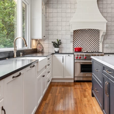 Galley View of White Shaker Cabinets and Custom Hood