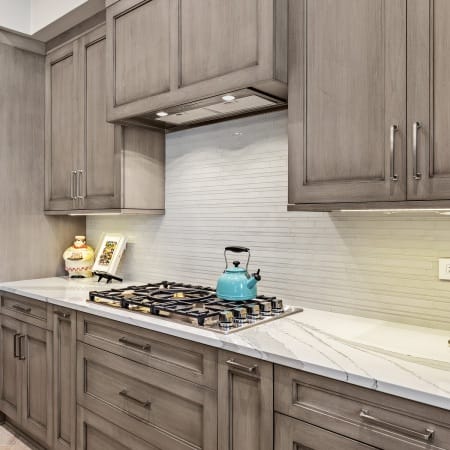 Sleek Backsplash with Built-In Hood. Brushed Nickel Door Handles.