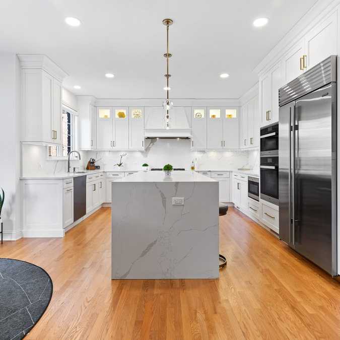Mitered edge quartz countertop, pendant lighting, floor to ceiling cabinetry