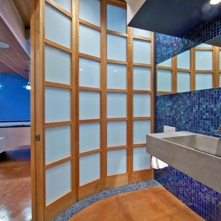 Rounded Powder Room with Cement Sink and Mosaic Tile Backsplash