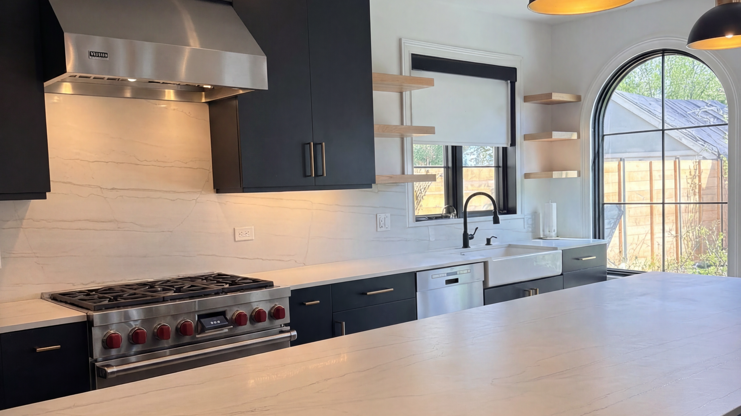 Remodeled kitchen in Kenilworth, IL with dark cabinets, white countertops, and open shelving.